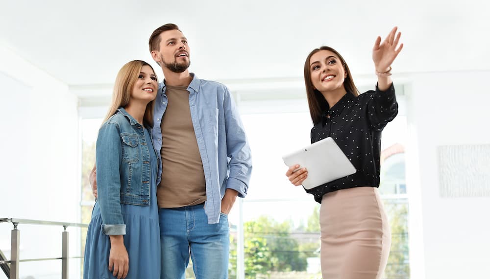 A realtor gives a couple a tour of a new home