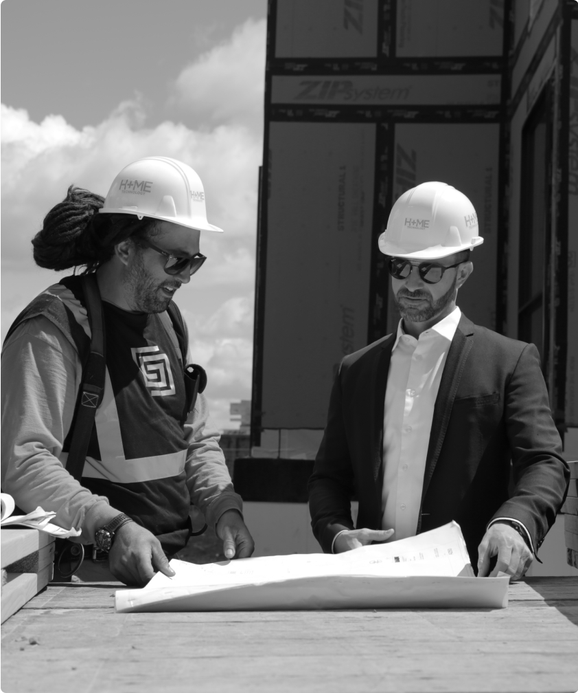 A Construction worker reviews a blue-print with the site Supervisor